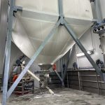 Flexible textile silo with vibrating bottom containing bulk sugar