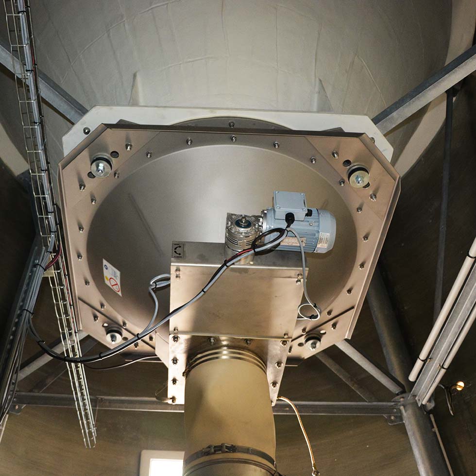 Vibrating bottom installed at the base of a composite silo